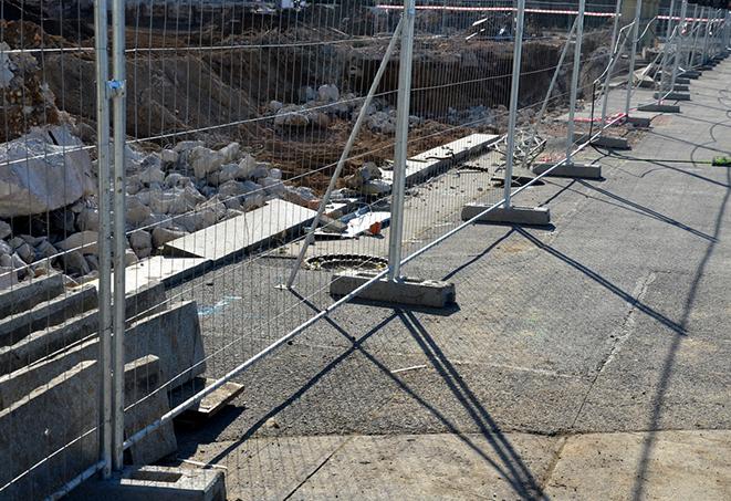 temporary fence panels used along a busy street to direct and control traffic